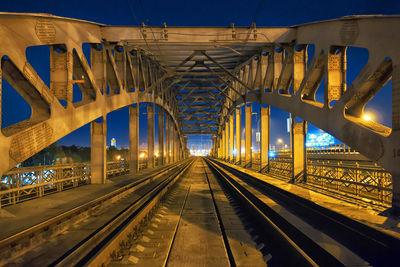 Railway bridge against sky at night