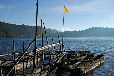 Bots moored in lake against sky