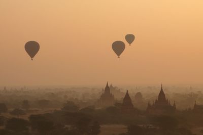 Hot air balloons in sky at sunset