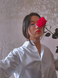 Close-up of woman standing against pink wall