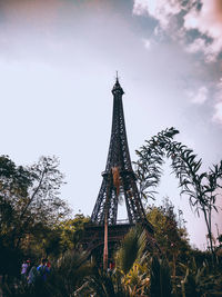 Low angle view of ferris wheel against cloudy sky