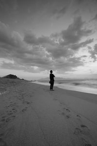 Silhouette man standing on beach against sky