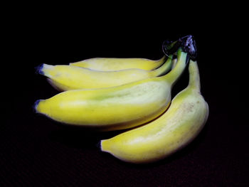 Close-up of bananas on table against black background