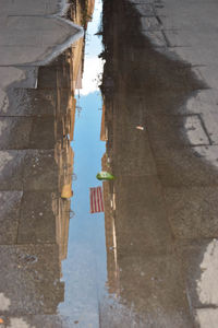 Reflection of built structure in puddle