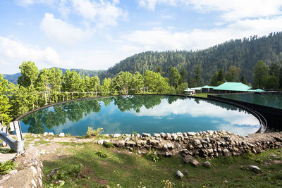 Scenic view of lake by trees against sky