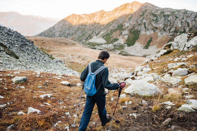 Rear view of man with arms raised on mountain