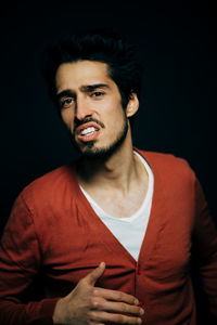 Portrait of young man against black background