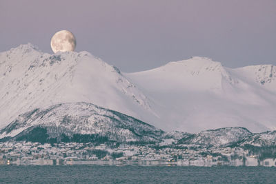 Scenic view of snowcapped mountains by sea against sky