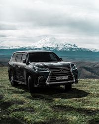 Abandoned car on land against sky