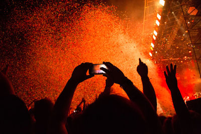 Silhouette of people photographing at concert