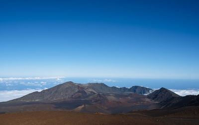 Scenic view of mountains against blue sky