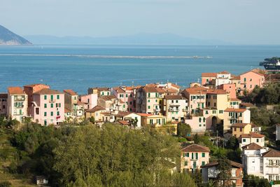 Buildings by sea against sky