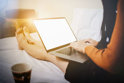 Midsection of man using laptop on table