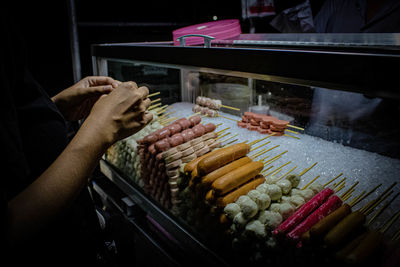 Cropped hand of person selling food at market stall