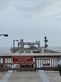 Text on pier against sky