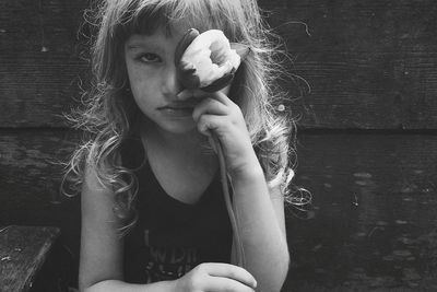 Close-up portrait of sad girl holding flower