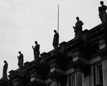 Low angle view of statue against building in city