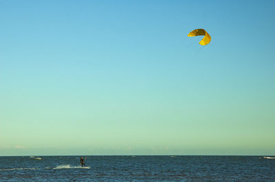 People in sea against clear sky