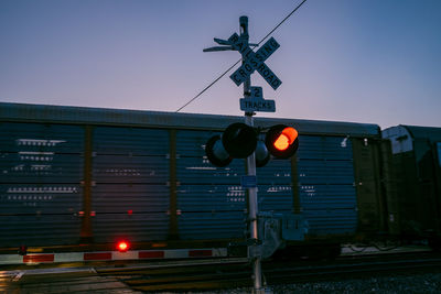 Low angle view of road sign against clear sky at dusk