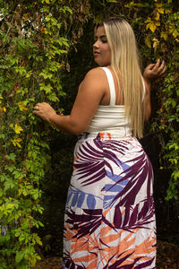 Young woman standing by plants