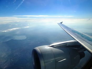 Cropped image of airplane wing over landscape