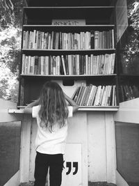 Rear view of woman standing on open book