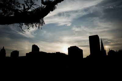 Silhouette of buildings against cloudy sky