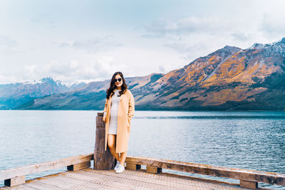 Woman standing on mountain against sky