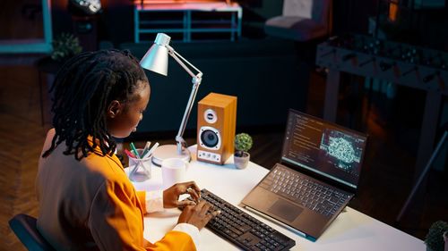 Rear view of woman using laptop on table