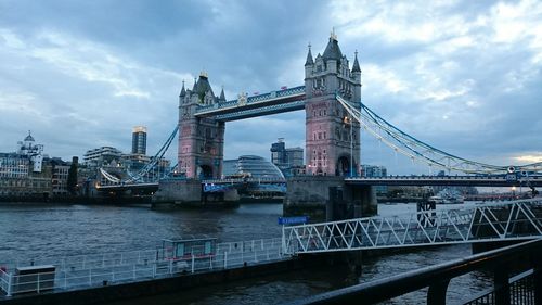 Bridge over river against cloudy sky