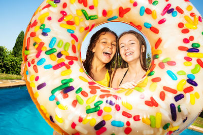 Portrait of smiling girls looking through inflatable ring