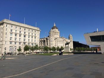 Buildings in city against clear blue sky