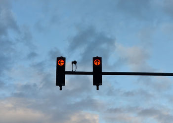 Low angle view of road sign against sky