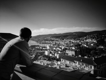 Man in city against sky