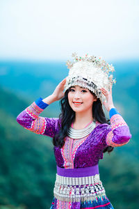 Portrait of a smiling girl standing against the sky