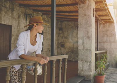 Side view of young woman sitting on steps