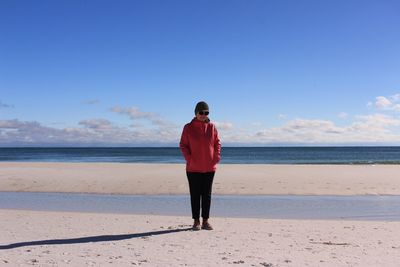 Full length of man standing on beach against sky