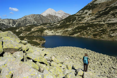 Man surfing on rocks against mountains