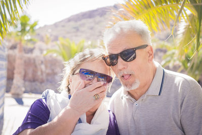 Senior couple wearing sunglasses at beach during summer