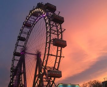 Low angle view of ferris wheel against sky at sunset