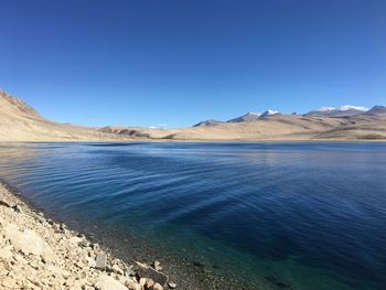 Scenic view of lake against clear blue sky