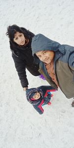 High angle portrait of family standing on snow