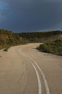 Road by trees against sky