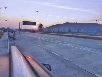 Empty road against sky during sunset