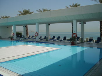 People at swimming pool against sky