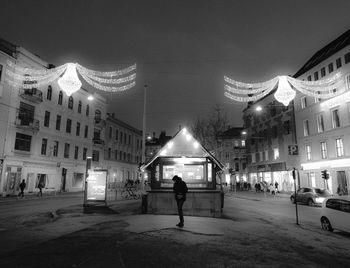 Woman in illuminated city against sky at night