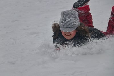 Smiling girl playing on snow