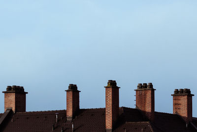 Low angle view of chimneys on building against sky