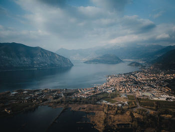 Aerial view of townscape by sea against sky