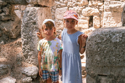 Kids sibling girl and boy travelers travel and explore the ancient excavations of the ruins